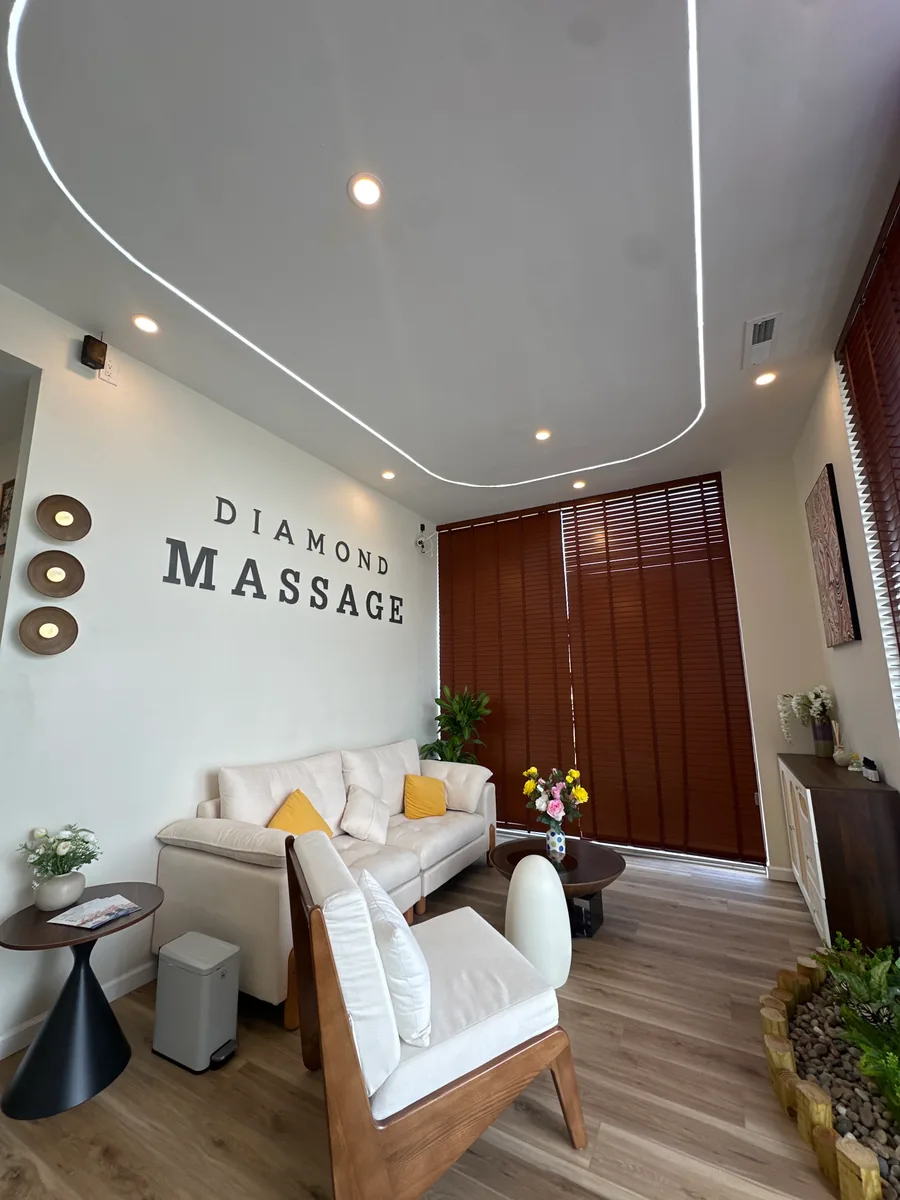 The lounge from the door: DIAMOND MASSAGE painted above a cream sofa with mustard cushions