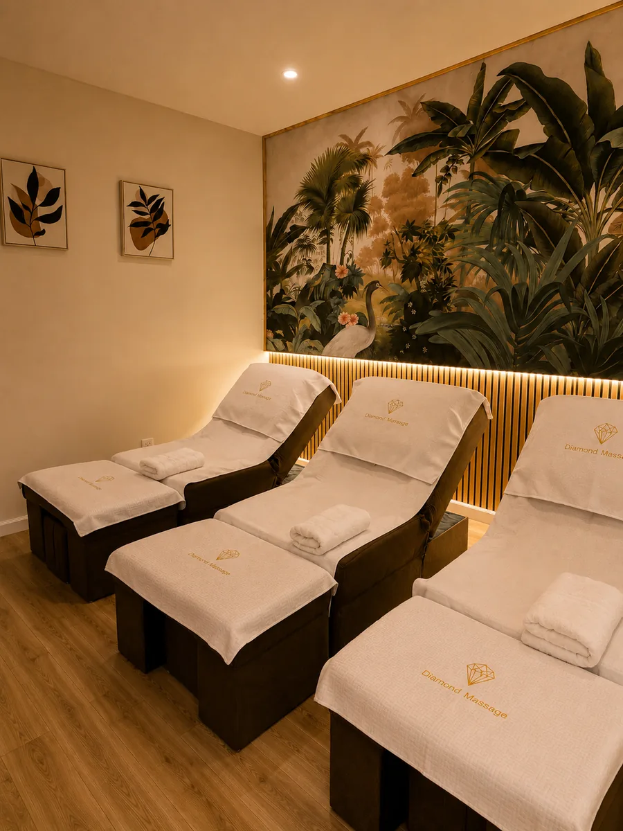 Three reclining foot-massage chairs at Diamond Massage under a jungle mural, each with a Diamond Massage towel folded on it